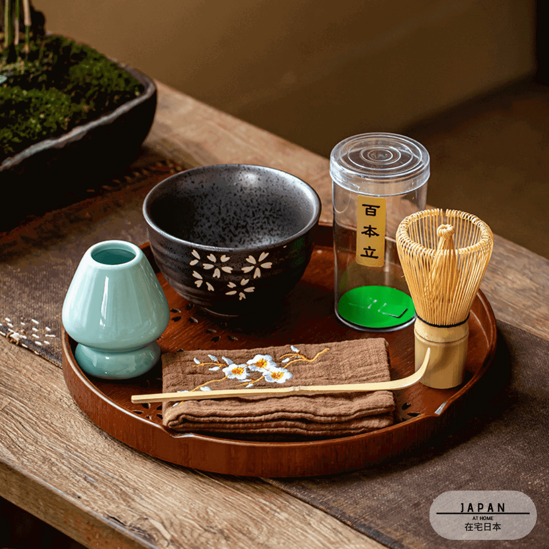 Kit matcha sur plateau rond, bol noir à fleurs et porte-fouet céladon