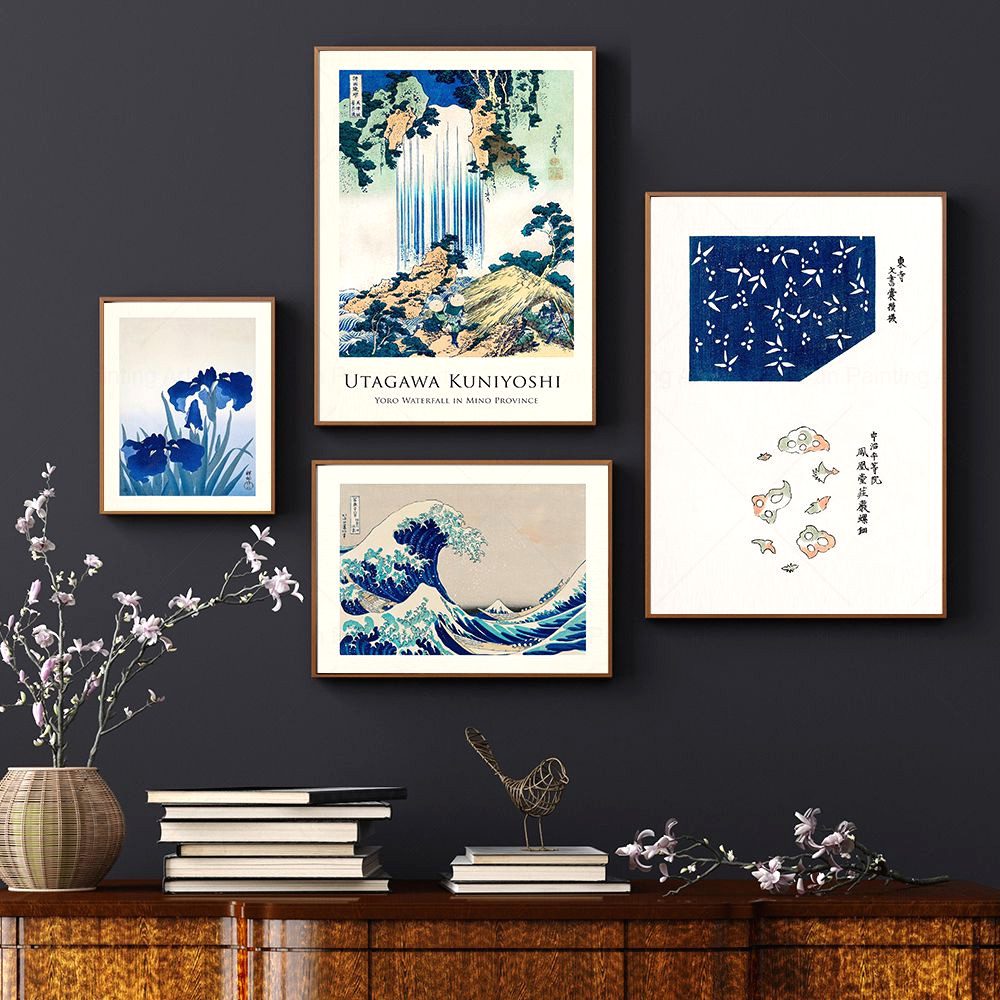 Quatre affiches estampes ukiyo-e encadrées sur un mur sombre au-dessus d'un buffet