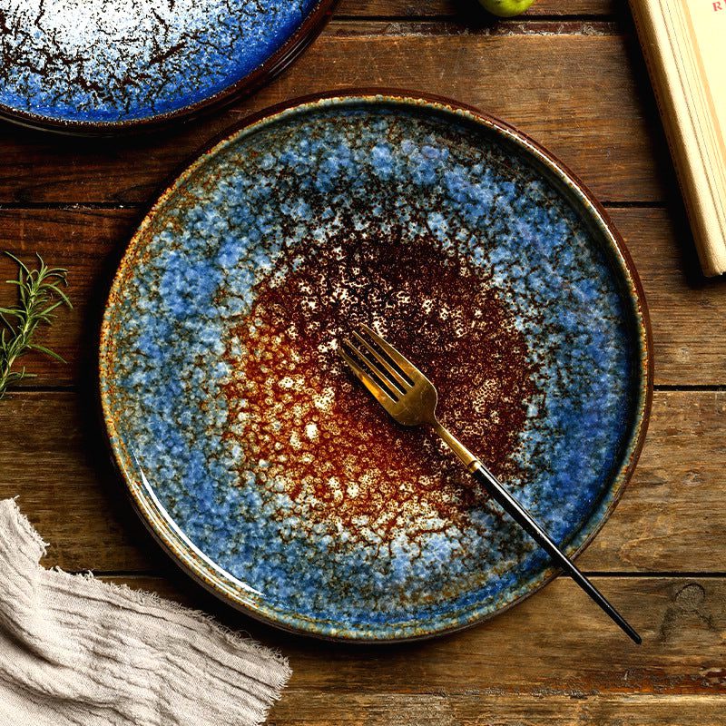 Assiette japonaise Hi to kōri ocre et bleu avec fourchette dorée sur une table en bois