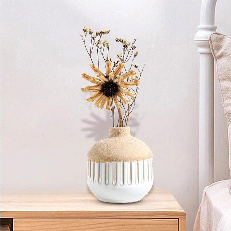 Vase japonais Shizuka sphérique rayé avec fleurs séchées sur une table de chevet