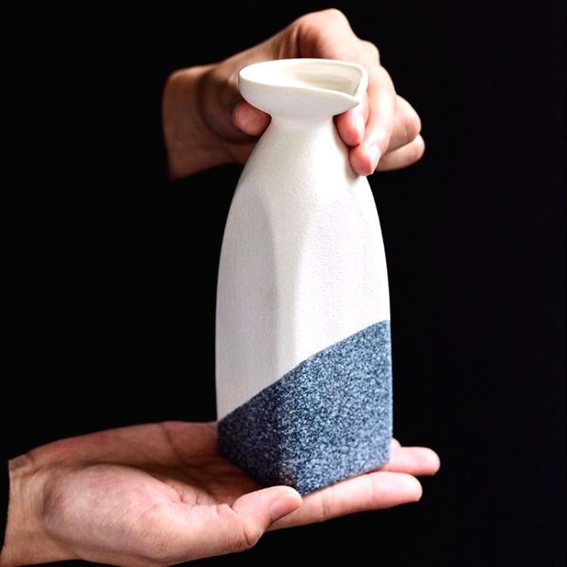 Carafe à saké Iwao blanc et bleu tenue à deux mains