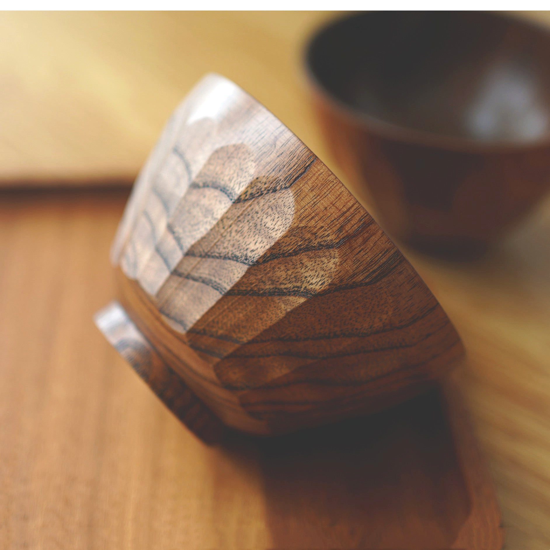 Bol en bois Ōryōki couché sur le côté, détail des facettes et du veinage