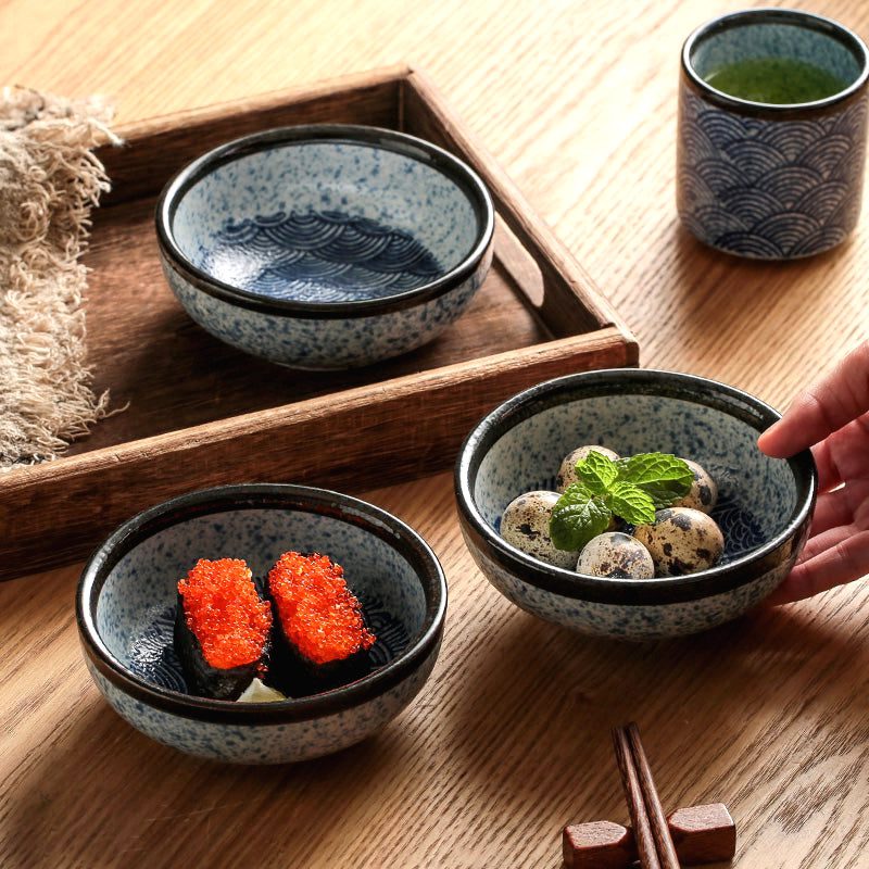 Trois bols à riz Seigaiha sur une table, plateau en bois et tasse de thé