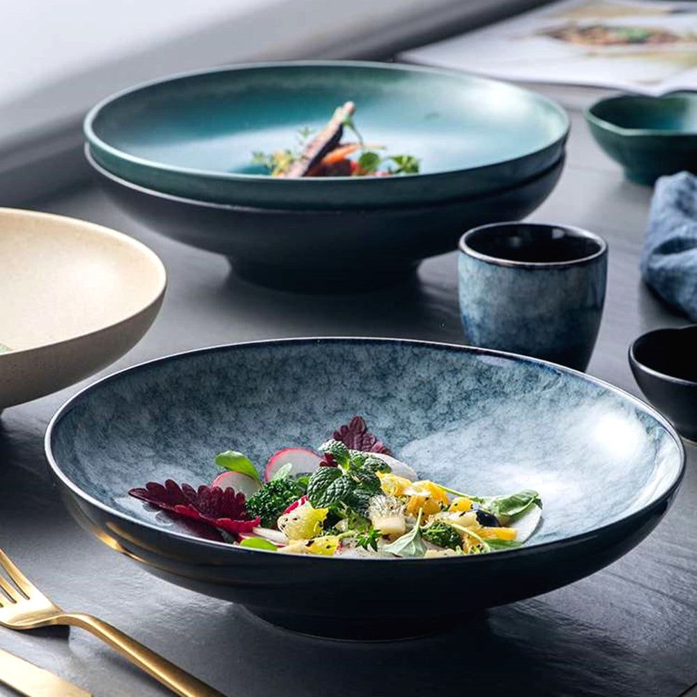 Assiette creuse Seiran bleutée avec salade, d'autres bols en arrière-plan