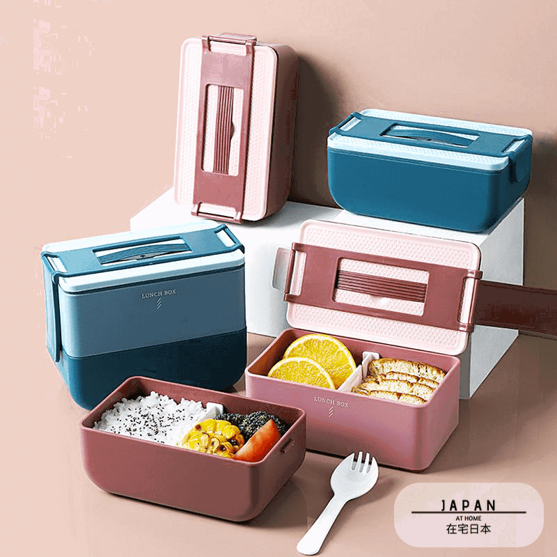Bentos portables roses et bleus ouverts, garnis de riz et de fruits, avec fourchette