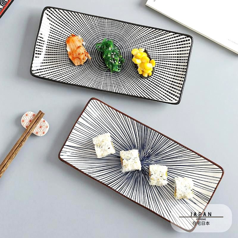 Deux assiettes à sushi rectangulaires garnies de sushis, avec baguettes